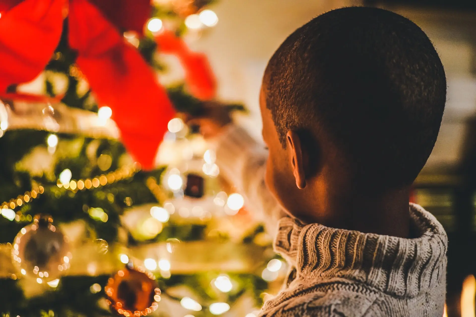 Boy near lit Christmas tree