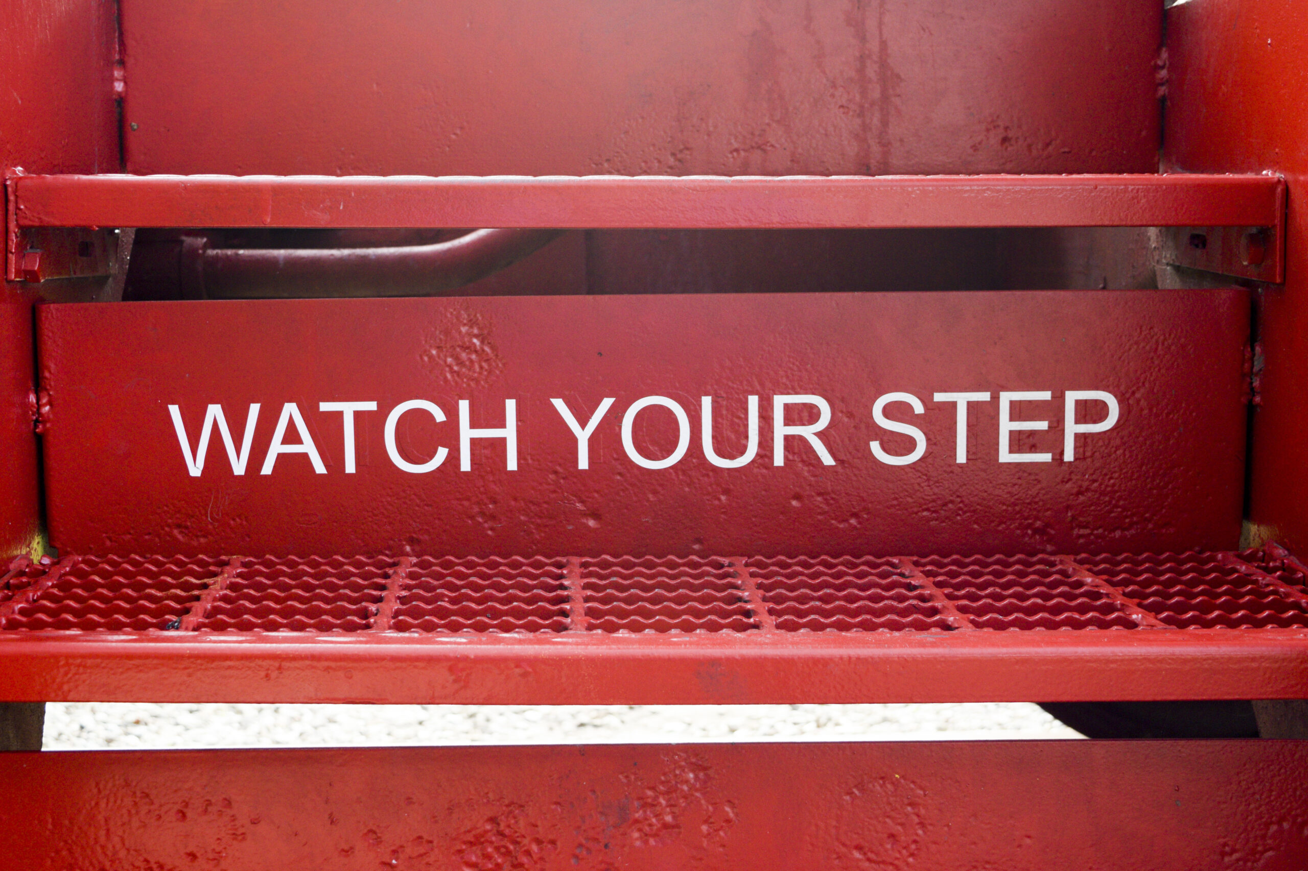 Red stairs with white text, "Watch Your Step"