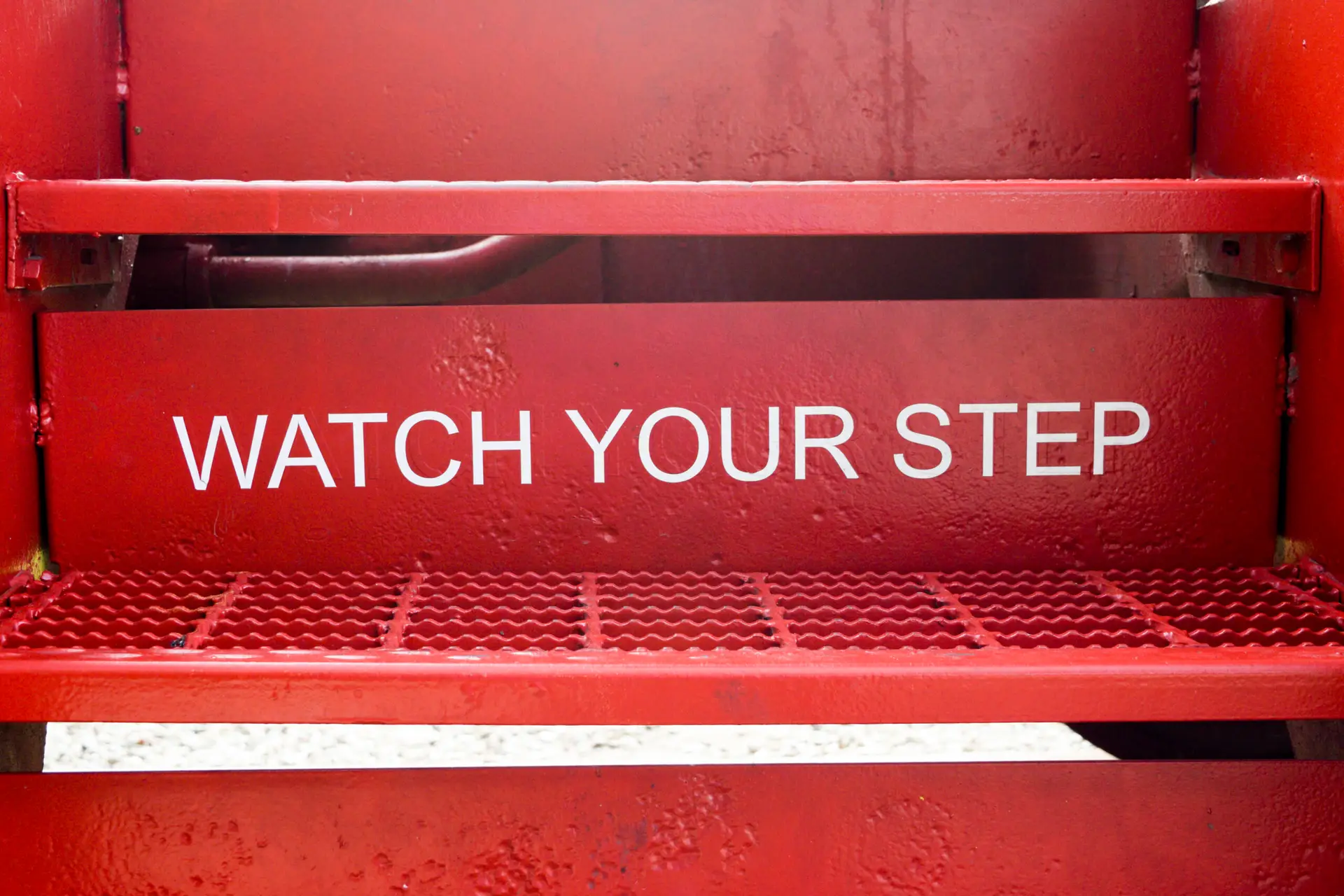 Red stairs with white text, "Watch Your Step"