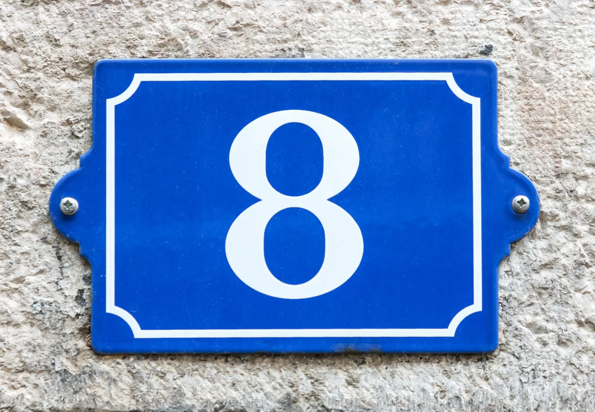 Close-up of vintage blue enamel house number eight on wall