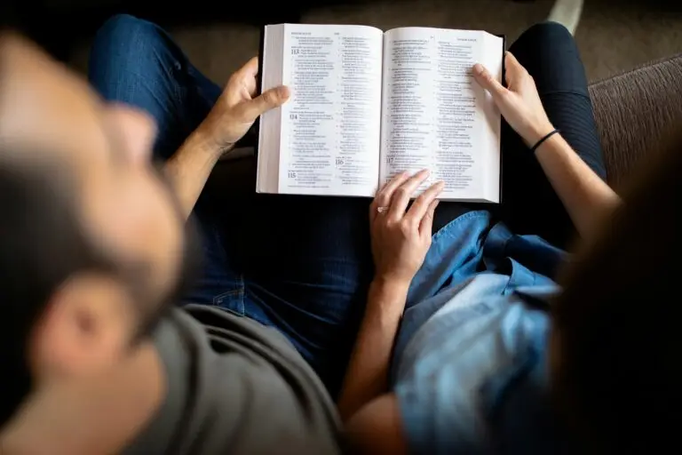 Couple reading bible together on church pew