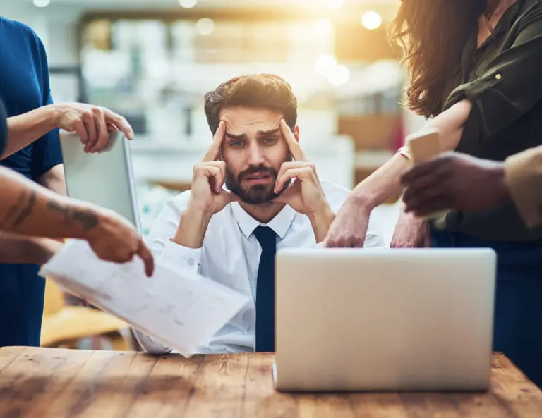 young man looking anxious in a demanding office environment