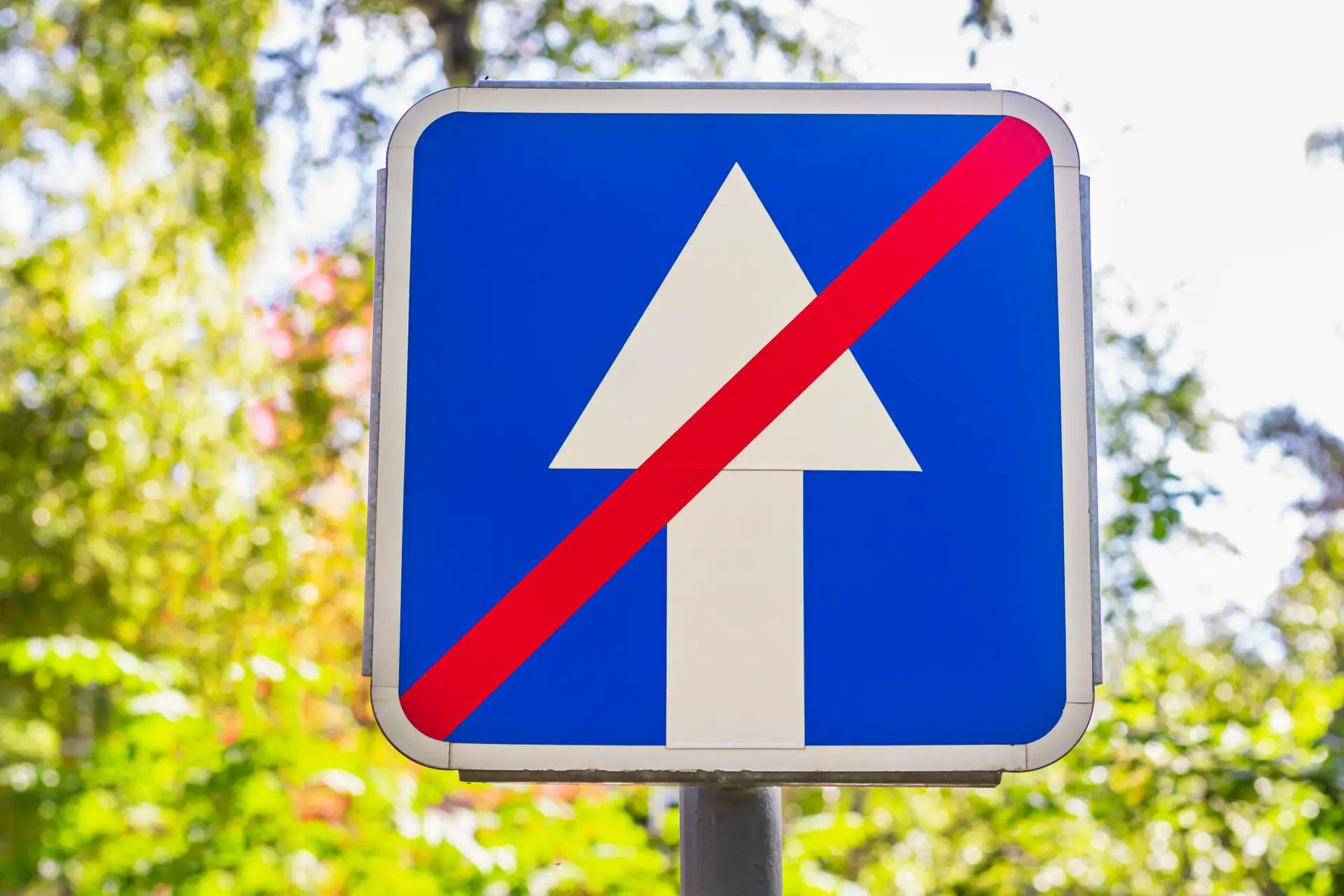 Blue square with white arrow crossed by red line traffic sign