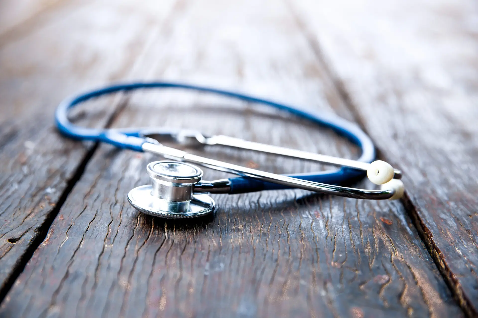 Stethoscope with blue tube on dark wood table