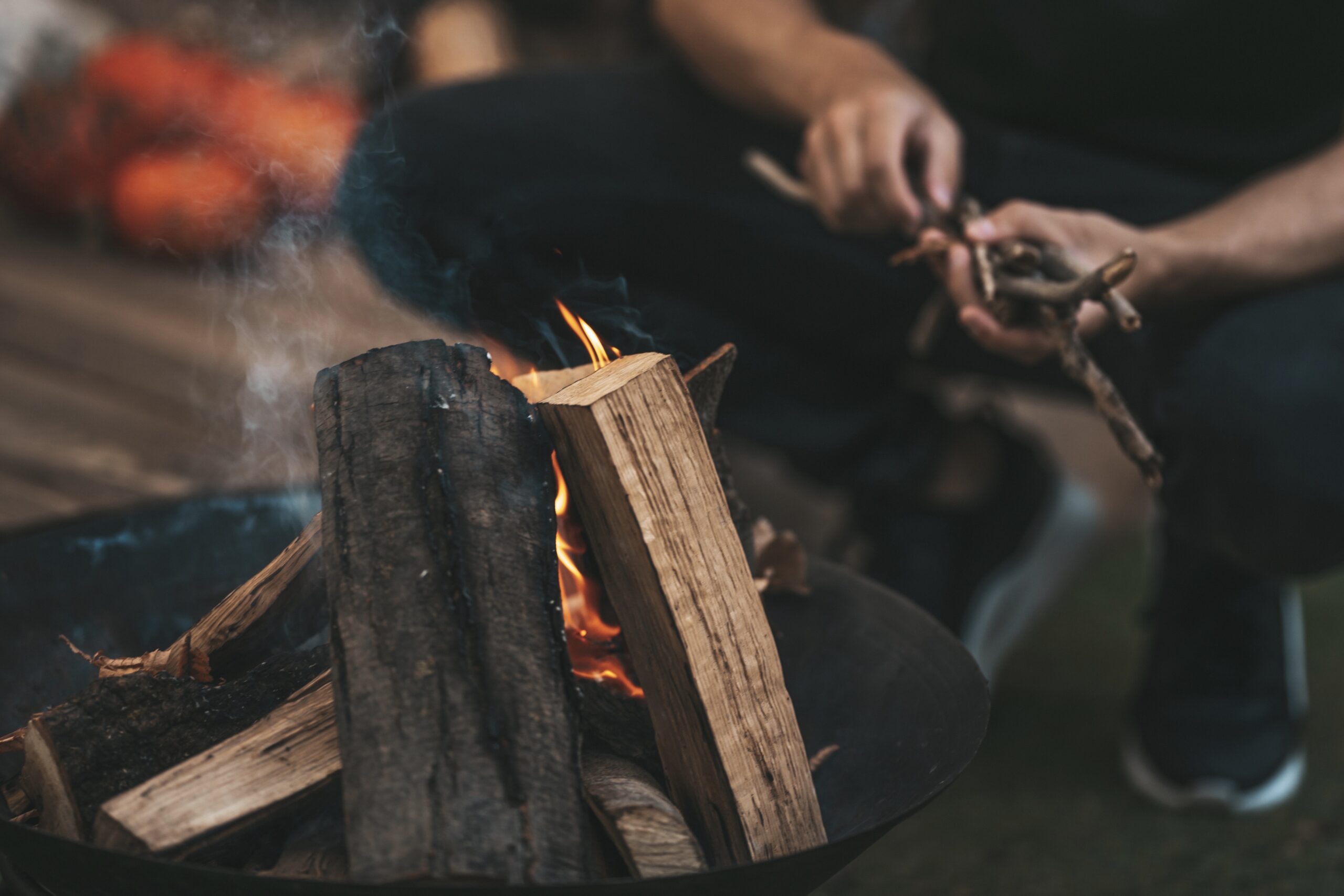 Man feeding a fire with firewood